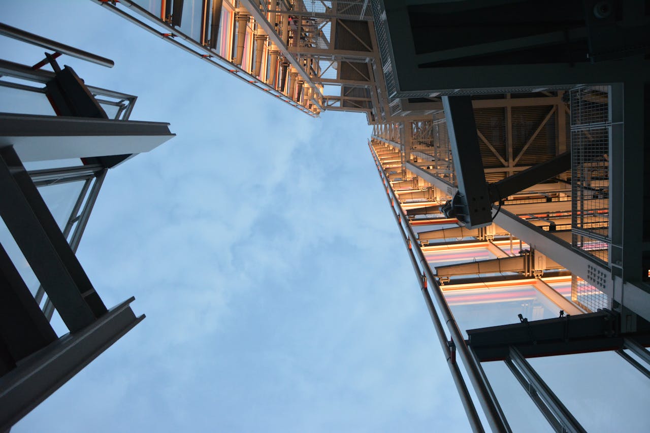 gallery-5 Low angle shot of modern steel structure reaching into the sky, daytime.