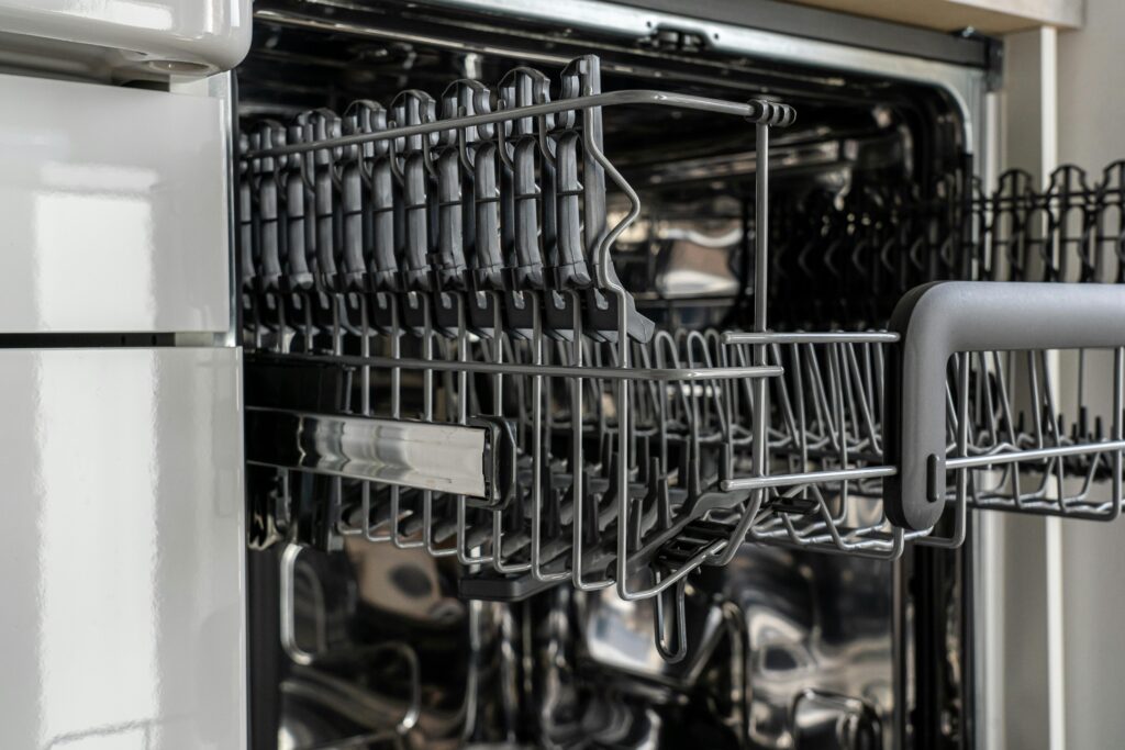 pexels photo 3829555 3829555 A detailed view of an empty modern dishwasher rack showcasing its stainless steel construction.
