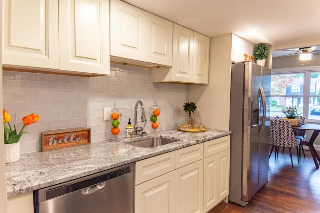 pexels photo 8824328 8824328 1 A stylish modern kitchen featuring white cabinets, granite countertops, and a stainless steel refrigerator. Bright and inviting.